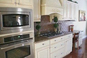Custom Home Kitchen, Wall-mounted Double Stack Ovens, Granite Counters, Faux-Brick Backsplash, Custom Range Hood; - Madison Custom Homes Inc., Indianapolis, Indiana