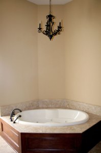 Close-up View: Master Bath Jacuzzi Tub, Carved Hardwood Enclosure, Granite Tile Rim / Backsplash, Wrought Iron Light Fixture Indianapolis Contractor, Central Indiana, Madison Custom Homes Inc.