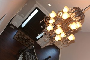 Chandelier, Carpeted Hardwood Staircase, Oak / Wrought Iron Banisters, Crown Molding Accents